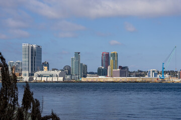 Fototapeta premium skyscrapers, office buildings, the San Diego Convention Center and cranes along the coast of the San Diego Bay at Coronado Tidelands Park in Coronado California USA
