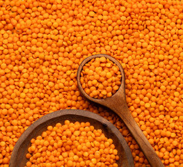 Raw red lentils in a bowl and spoon - Lens culinaris.
