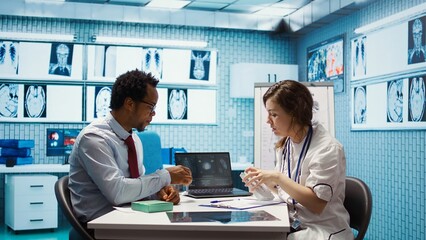 Doctor giving woman a pill from the medicine tablet to start treatment with antibiotics, recommending the right dosage for remedy. Specialist provides prescription drugs with instructions. Camera B.