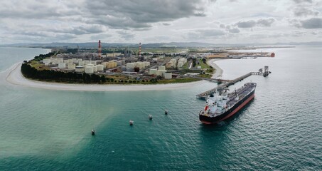 Petroleum tanker, coastline and storage silos at the decomissioned Marsden Point Refinery,...