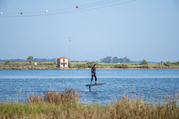 Silhouetted man on a hydrofoil surfboard