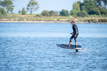 Silhouetted man on a hydrofoil surfboard