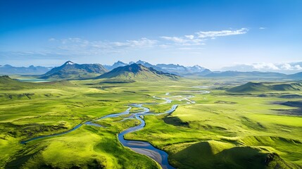 Aerial view of a vibrant green valley with winding rivers and distant mountains under a clear blue sky