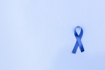 Blue ribbon on a blue background and space to write, ideal for Blue November campaigns, prostate...