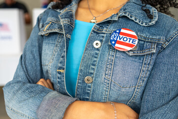 close up on a 2024 vote pin button of a young African American woman smiling at a US election...