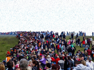 A crowd of people on the meadow watching the performance