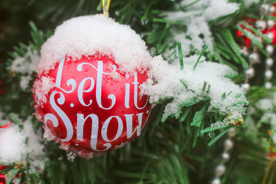 Holiday ball on tree that reads Let It Snow