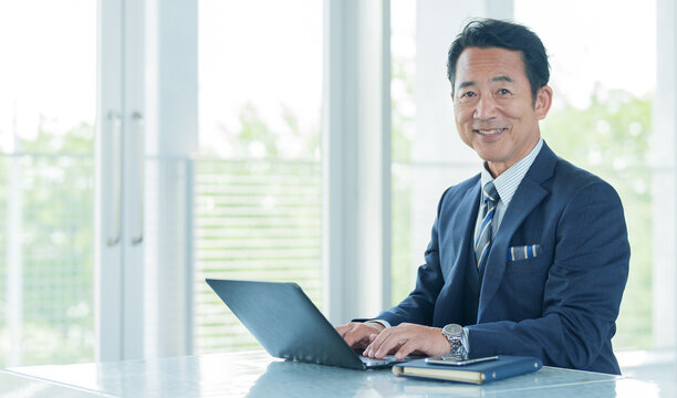 オフィスでパソコンを使う中高年のビジネスマン