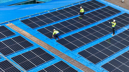 engineer man inspects construction of solar cell panel or photovoltaic cell by electronic device. Industrial Renewable energy of green power. factory worker working on tower roof.