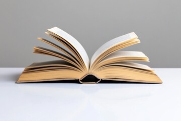 Fototapeta premium A minimalist image of an open book on a clean white table, symbolizing the simple joy of reading for book lovers