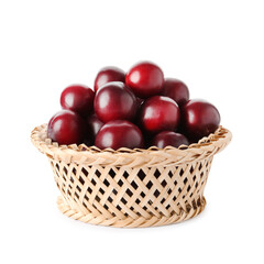 Fresh ripe plums in wicker bowl isolated on white