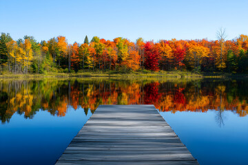 Serene Lakeside Scene: Tranquil Autumn Reflections with Vibrant Fall Colors and Wooden Pier