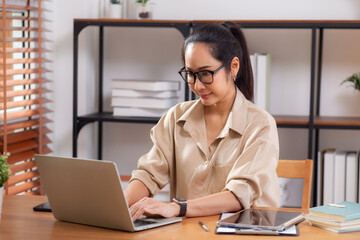 Happiness young businesswoman using laptop computer on desk in living room at home office, business woman using laptop for surfing internet, entrepreneur or freelance, business and communication.