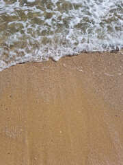 
It is a sandy beach with waves rolling in.