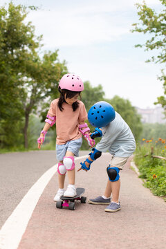 Happy Boy And Girl Skateboarding