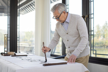 Senior Man Practicing Chinese Calligraphy