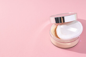 A bottle of powder, light shade, on a pink background.