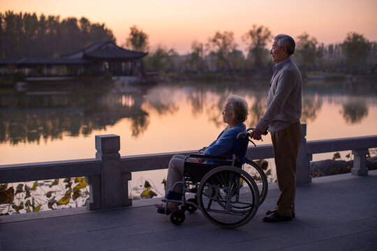 Senior Man Pushing Wife in Wheelchair
