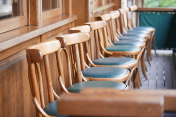 A row of beautifully crafted wooden chairs adorned with green cushions in a cozy, inviting setting
