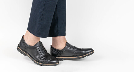 Close-Up of Men's Black Leather Shoes with Professional Navy Pants on White Background