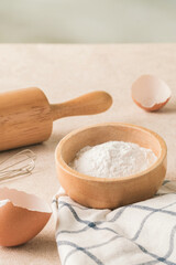 Pastry dough in wooden bowl in kitchen with baking equipment. Morning photo. Holiday food concept.