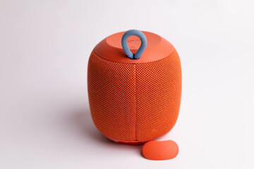 The back of a red Bluetooth speaker is showcased against a white background, emphasizing its sleek...