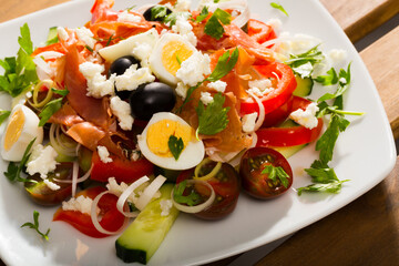 Traditional Shepherd's salad with salmon, fresh tomato, cucumber and quail eggs