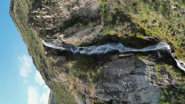 Vertical format aerial orbits Caryacuyo Waterfall in southern Peru