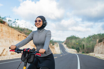 hijab woman smiling when riding bike, outdoor activity, healthy lifestyle, biking concept