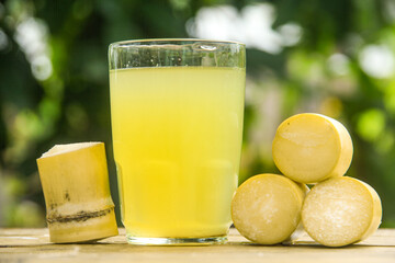 Drink from sugar cane juice, squeezed sugar cane juice with sugar cane stalks and natural background
