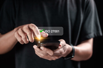 Person using smartphone to choose ISO 27001 for information security management system (ISMS),...