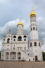 Ivan the Great Bell Tower, with Assumption Belfry on the right in Moscow Kremlin. Blue sky background with sunbeams