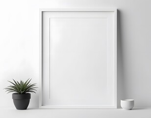 White vertical frame mockup leaning on white wall with plant and cup