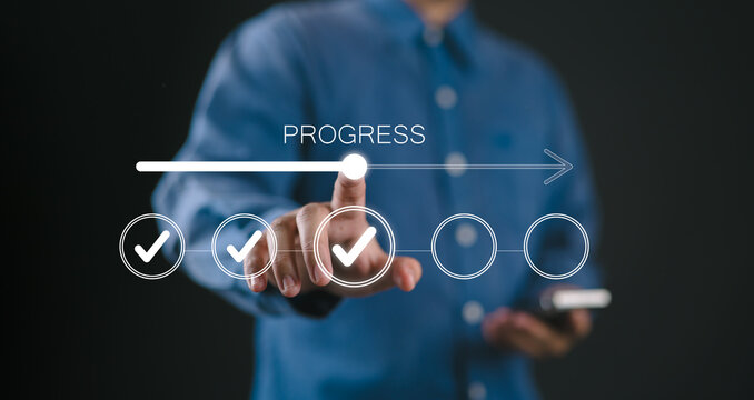 Businessman touches a digital progress checklist with check marks and an advancing loading bar, symbolizing task completion and project progress. progress bar, Management and tracking strategies,