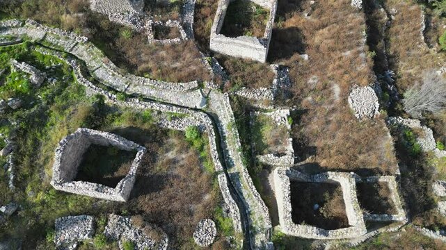 Aerial looks down onto stone ruins of Uyo Uyo town site in south Peru