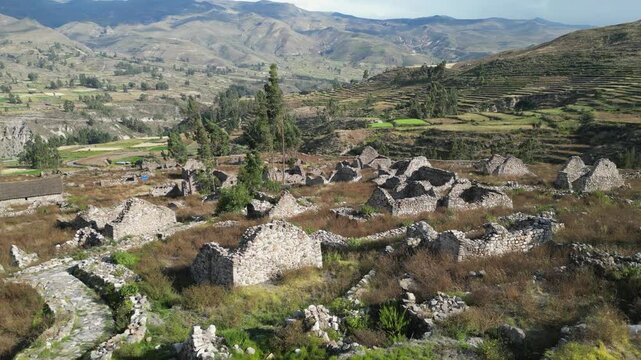 Aerial orbits long abandoned stone ruins of Uyo Uyo site in Peru