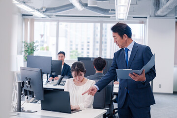 オフィスで上司から叱責をされる若い女性社員