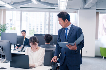 オフィスで上司から叱責をされる若い女性社員