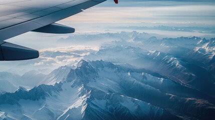 Fototapeta premium A breathtaking view of snow-capped mountains from an airplane window, showcasing the wonders of flight.