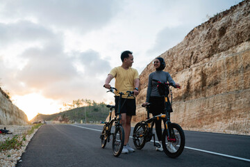 Fototapeta premium male and female biker riding bike together