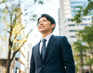空を見上げるスーツ姿の若い男性