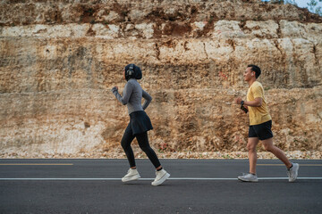 athletic couple running together on the road, jogging concept