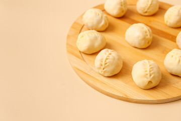 Close-up of savory Central Asian manti with meat on rustic wooden surface, frozen dumplings, place for text.