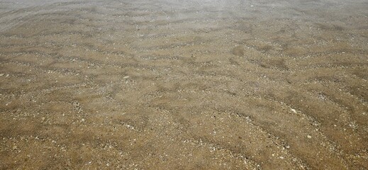 Ocean wave texture on sand beach in water background landscape.