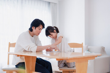 Fototapeta premium パパと一緒にパズルゲームをする小さな女の子