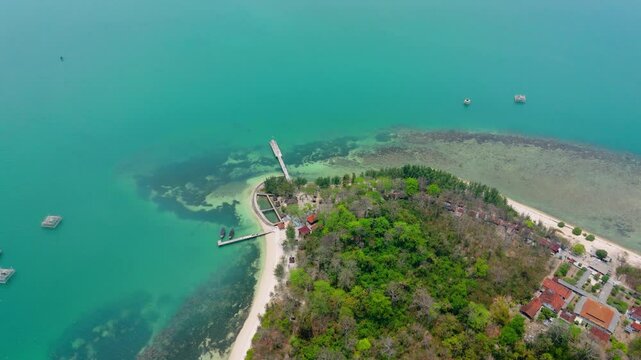 Drone flying through tropical island with clam blue sea in Jepara, Indonesia