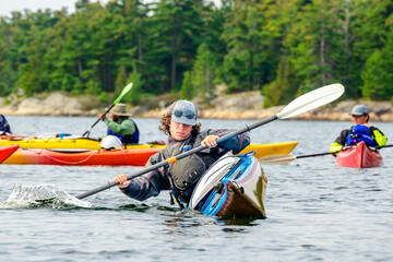 young man paddling a sea kayak on Georgian Bay room for text