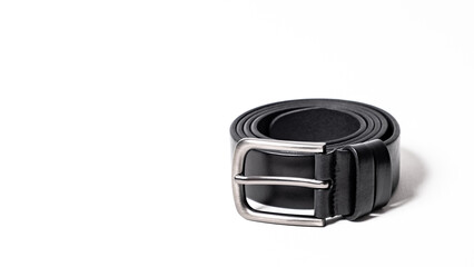 Twisted black leather belt with matted metal buckle isolated on white background. Fastened...