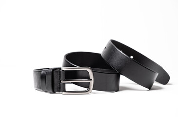 Black leather belt with matte metal buckle close-up isolated on white background. Fashionable...