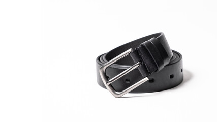 Twisted black leather belt with matted metal buckle isolated on white background. Fastened fashionable unisex, man or woman accessory for trousers, jeans, dress. Male luxury strap. Haberdashery goods